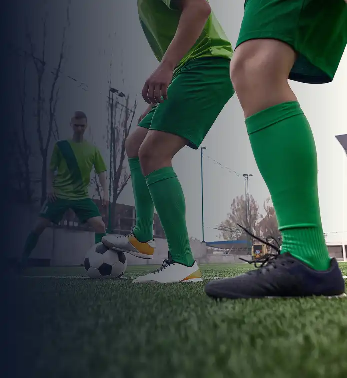 Voetballers in groene tenues op het veld.